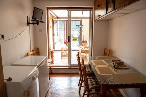 巴利海吉Sheila's Cottage Ballyheigue的厨房以及带桌子和窗户的用餐室。