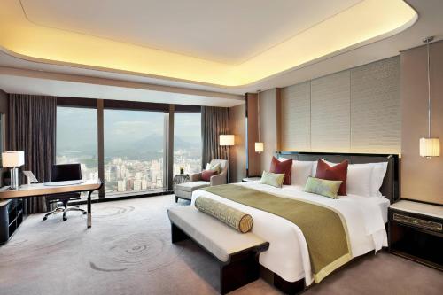 深圳深圳瑞吉酒店的一间大卧室,配有一张大床和一张书桌