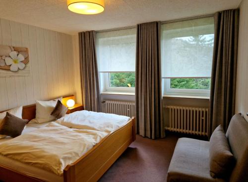 维林根Ferienwohnungen Tannenhof的一间卧室设有一张床和两个窗户。