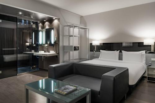 马德里阿托查万豪AC酒店的酒店客房,配有床和沙发