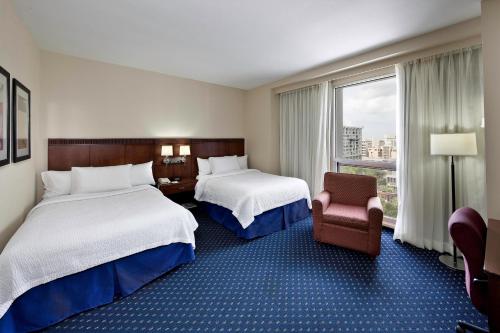 圣胡安圣胡安米拉马尔万怡酒店的酒店客房带两张床、椅子和窗户