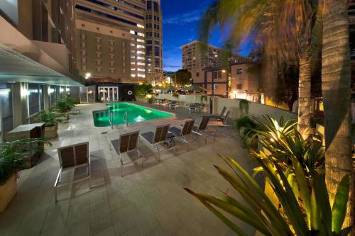 圣胡安圣胡安米拉马尔万怡酒店的一个带游泳池和桌椅的庭院