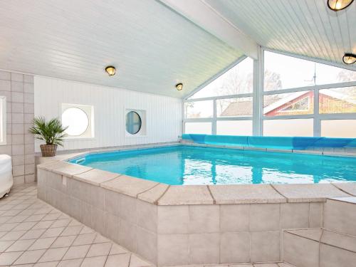 埃贝尔托夫特6 person holiday home in Ebeltoft的一座带大窗户的房屋内的游泳池