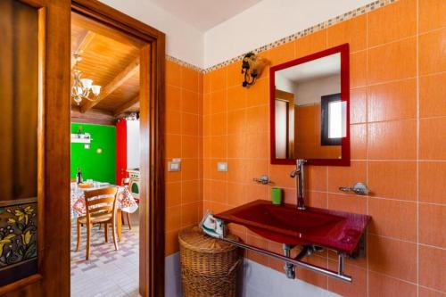 加利波利ATTICO SUL MARE的一间带红色水槽和镜子的浴室