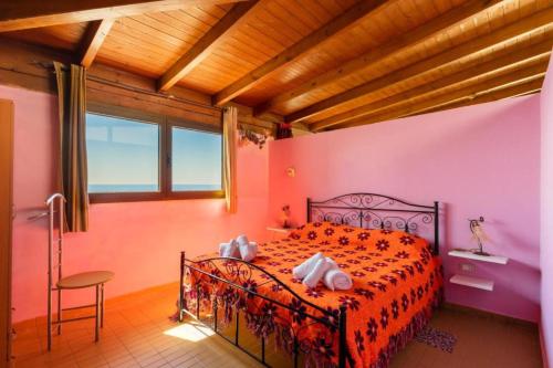 加利波利ATTICO SUL MARE的卧室配有一张床铺,位于一间粉红色墙壁的房间