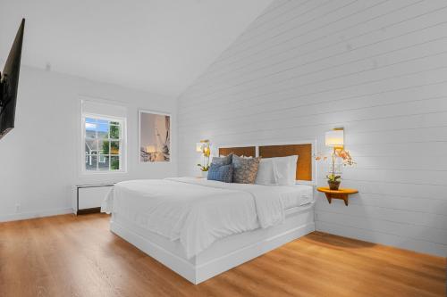 楠塔基特楠塔基特酒店的白色的卧室设有一张大床和一个窗户