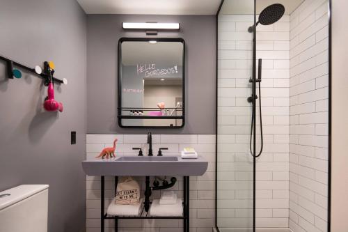 波特兰Moxy Portland Downtown的一间带水槽和镜子的浴室