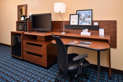 杰斐逊维尔Fairfield Inn & Suites Louisville North的一张桌子,配有电视和椅子,位于酒店的房间