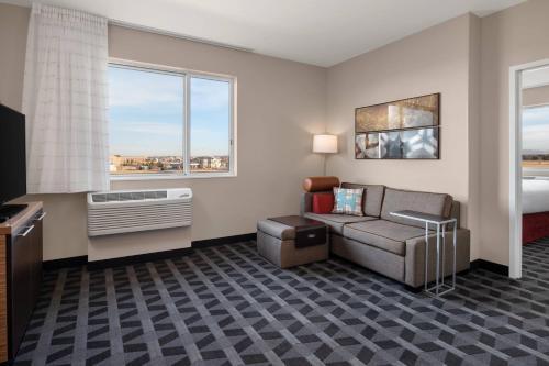 双子瀑布TownePlace Suites by Marriott Twin Falls的酒店客房设有沙发、床和窗户。
