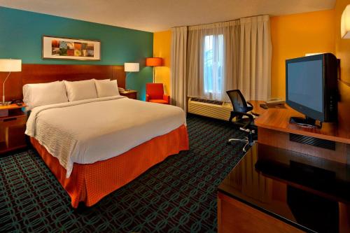 布卡拉顿布卡拉顿费尔菲尔德客栈的配有一张床和一台平面电视的酒店客房