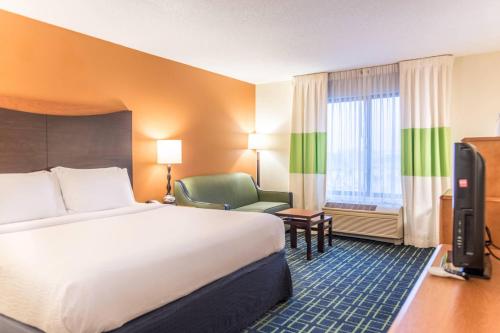 诺顿海岸Fairfield Inn & Suites by Marriott Muskegon Norton Shores的酒店客房带一张大床和一把椅子