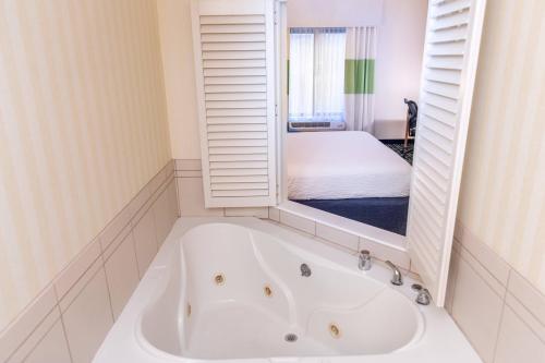 诺顿海岸Fairfield Inn & Suites by Marriott Muskegon Norton Shores的配有床铺的客房内的白色浴缸