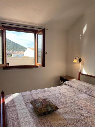 拉卡勒塔La casa di Tonia的一间卧室设有一张床和一个美景窗户。