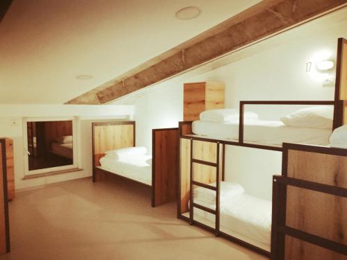 新戈里察GARAGE HOSTEL的带三张双层床和镜子的客房