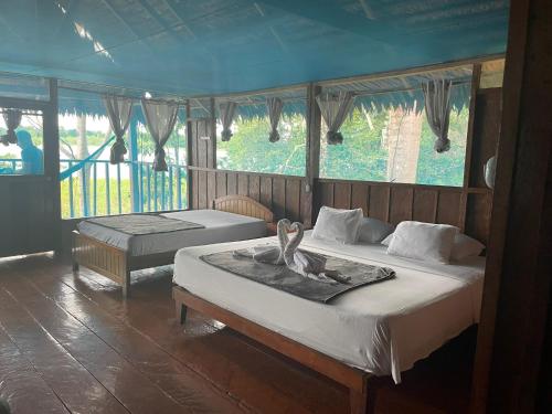 ParaísoYaku Amazon Lodge & Expeditions的一间卧室配有两张床,上面有天鹅