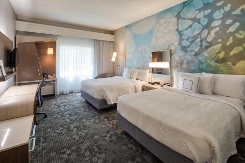 岩石丘岩石丘万怡酒店的酒店客房设有两张床,墙上挂有绘画作品