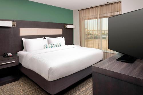 ElmwoodResidence Inn by Marriott New Orleans Elmwood的一间卧室配有一张大床和一台平面电视