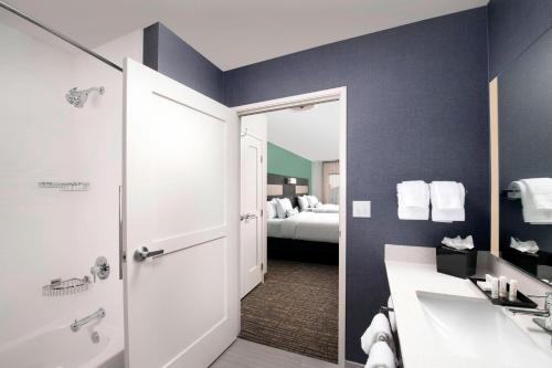 ElmwoodResidence Inn by Marriott New Orleans Elmwood的一间带水槽和淋浴的浴室以及一张床
