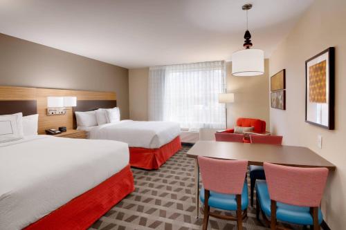 德雷珀TownePlace Suites by Marriott Salt Lake City Draper的酒店客房带两张床和一张桌子以及椅子。