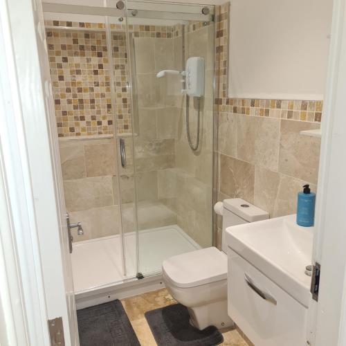 特伦特河畔伯顿Cozy apartment in Burton town centre的带淋浴、卫生间和盥洗盆的浴室