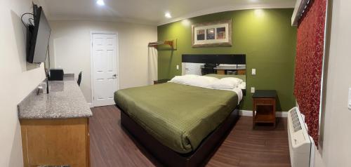 奥克兰哈里斯汽车旅馆的一间卧室配有一张带绿色墙壁的床