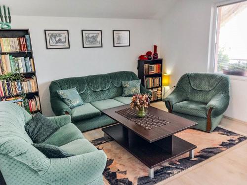 PetrovecMy Parents Guest House的客厅配有两张绿色沙发和一张咖啡桌