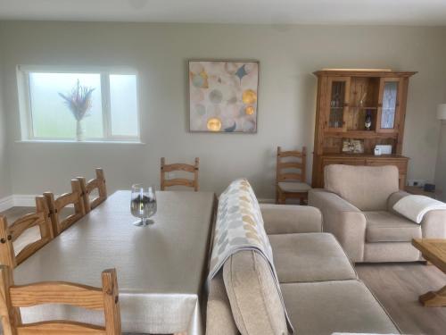 GrangeArd Alainn Lodge, Adorable Setting, scenic views的客厅设有餐桌和椅子