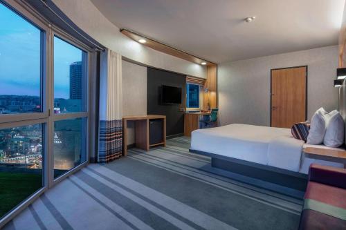 伯萨布尔萨雅乐轩酒店 的酒店客房设有一张床和一个大窗户