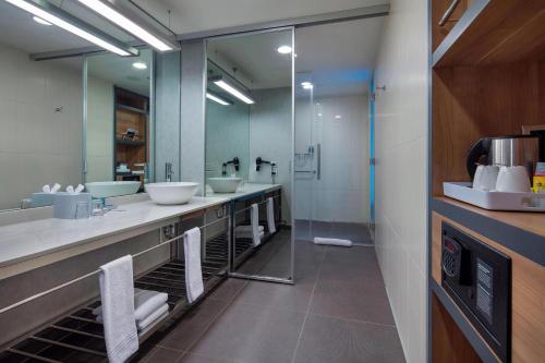 伯萨布尔萨雅乐轩酒店 的一间带三个水槽和大镜子的浴室