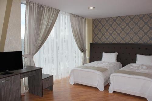 SilistraFamily Hotel Silistra的酒店客房设有两张床和电视。