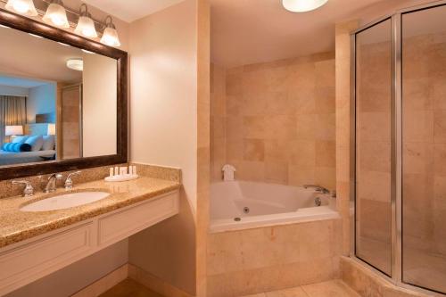 基拉戈拉哥岛万怡酒店的带浴缸、水槽和镜子的浴室