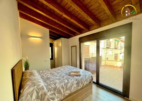 托莱多Casa de la GALERA的一间卧室设有一张床和一个滑动玻璃门