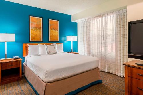 坦帕Residence Inn Tampa Westshore Airport的一间卧室配有一张大床和一台平面电视