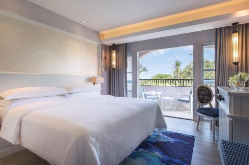 茶云莱海滩Sheraton Samui Resort的一间带一张白色大床的卧室和一个阳台