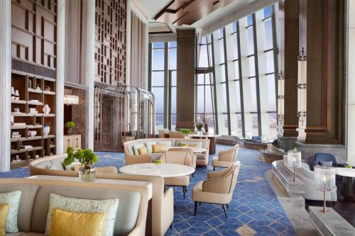 哈尔滨哈尔滨富力丽思卡尔顿酒店的大堂配有沙发、桌子和窗户。