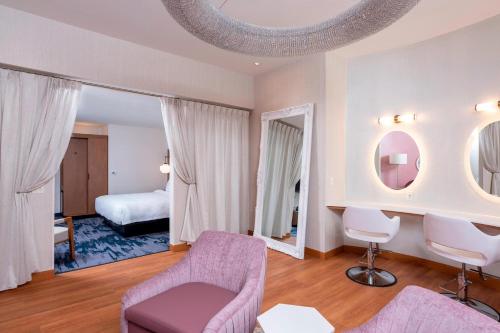 Fair OaksFairfield Inn & Suites by Marriott Fair Oaks Farms的一间带紫色椅子的客厅和一间卧室