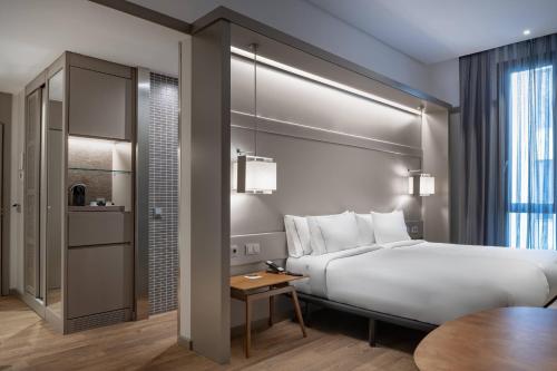 马德里雷科莱托斯万豪AC酒店的酒店客房配有一张床铺和一张桌子。