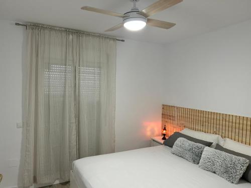 福恩吉罗拉FUENGIROLA Castillo Malaga PARADAISE 3的卧室配有白色的床和吊扇