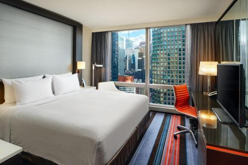 纽约纽约曼哈顿/中央公园万豪万怡酒店的酒店客房设有一张床和一个大窗户