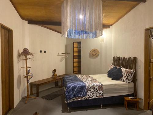 雅帕拉廷加Casa do Francês的一间卧室配有一张床和一个吊灯