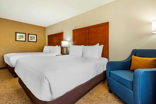 纳帕尼Comfort Inn & Suites的一张大床和一张蓝色椅子,位于酒店客房内