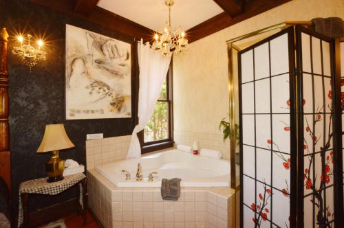 维多利亚马克塔住宿加早餐酒店的带浴缸、窗户和吊灯的浴室。