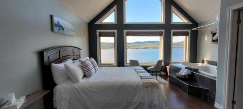 科纳布鲁克Coastal Lookout Suites的一间卧室设有一张大床和大窗户