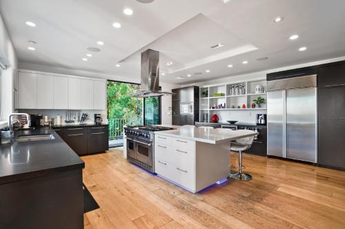 洛杉矶Villa Alana的一间铺有木地板并配有不锈钢用具的大厨房