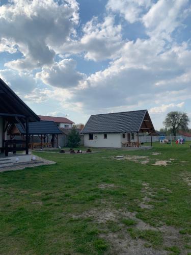 ŚwiętneDomek letniskowy 6-osobowy całoroczny nad jeziorem Wilczyńskim的一座农场,有两栋建筑和草地
