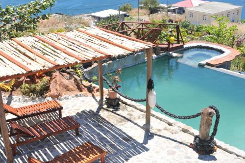 Saint Joseph芒果岛小屋酒店的游泳池,带两把椅子,周围有绳子