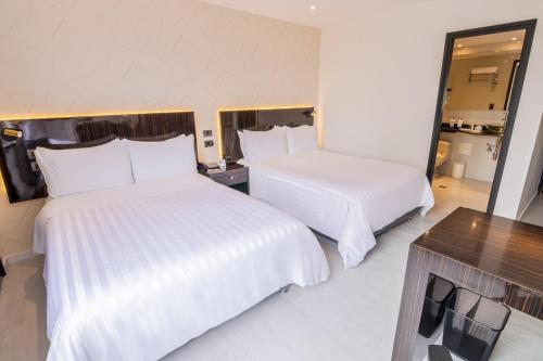 麦德林GHL Hotel Portón Medellín的酒店客房,设有两张床和镜子
