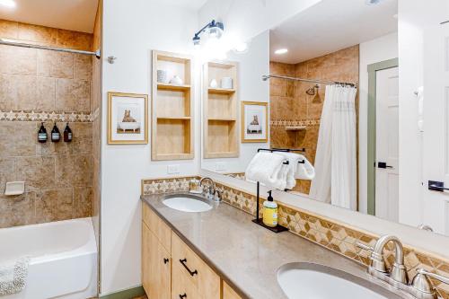 杜兰戈山度假胜地Cascade Village 308的浴室配有2个盥洗盆、浴缸和淋浴。