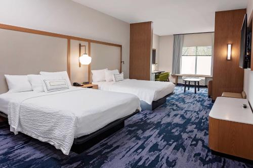 克林顿港Fairfield by Marriott Port Clinton Waterfront的酒店客房配有两张床和一张书桌