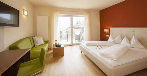 泰尔梅诺Hotel Residence Pernhof的一间卧室配有两张床、一张沙发和一台电视